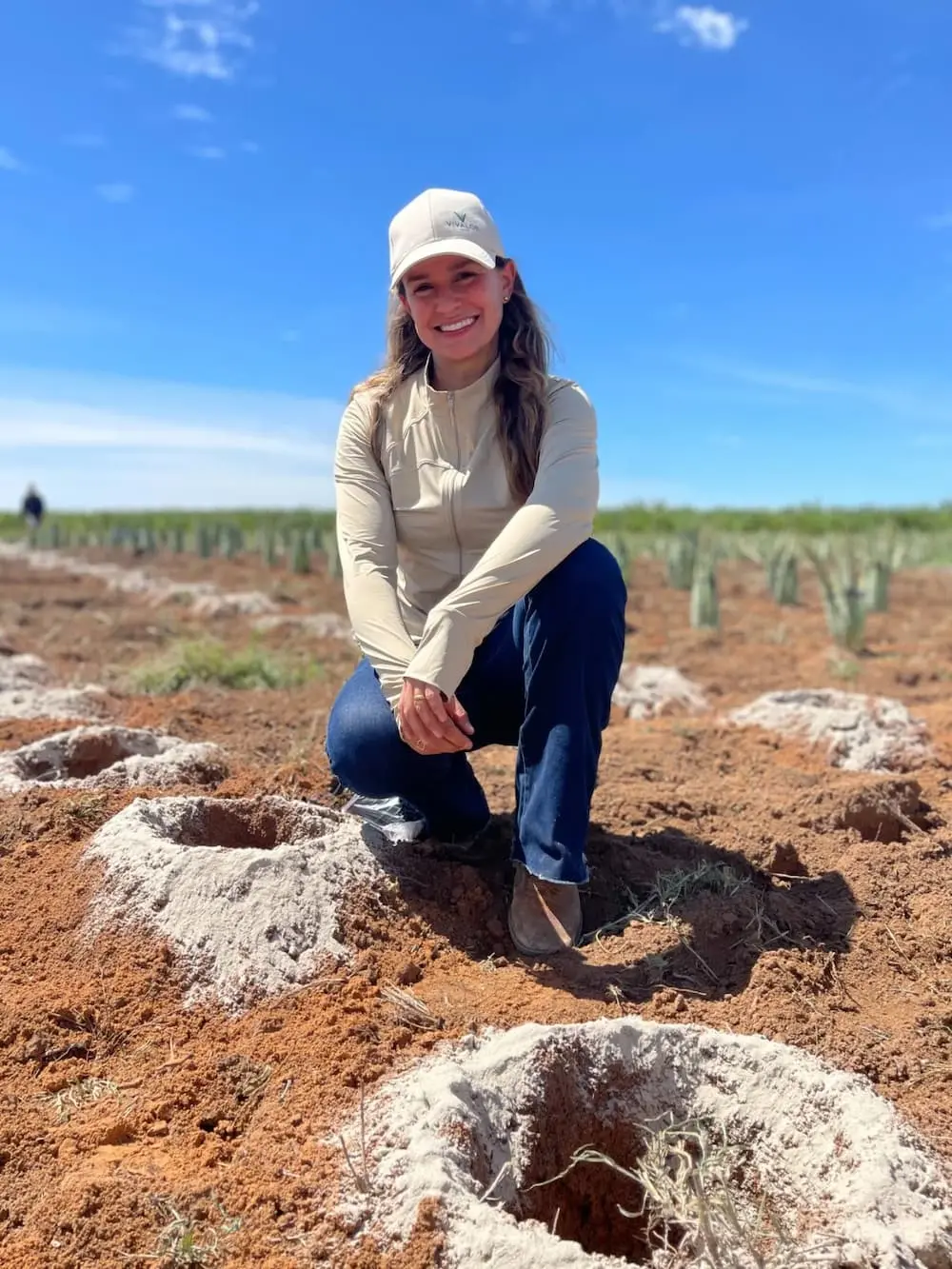 Fundadora da Vivaloe no campo de cultivo com covas preparadas para mudas